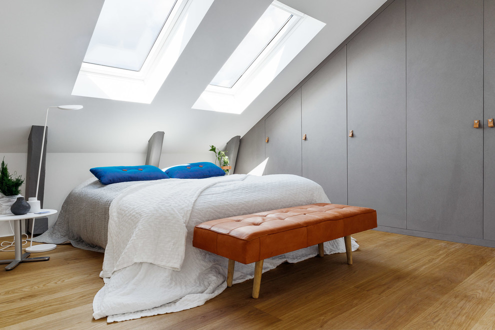 Danish master light wood floor bedroom photo in Stockholm with white walls