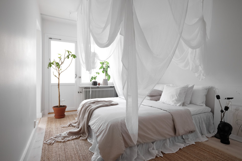 Réalisation d'une chambre parentale nordique de taille moyenne avec un mur blanc, parquet clair et un sol beige.