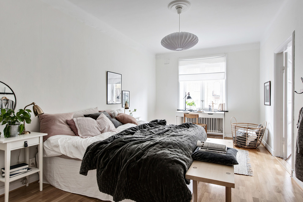 Foto de dormitorio principal nórdico grande con paredes blancas, suelo beige y suelo de madera clara