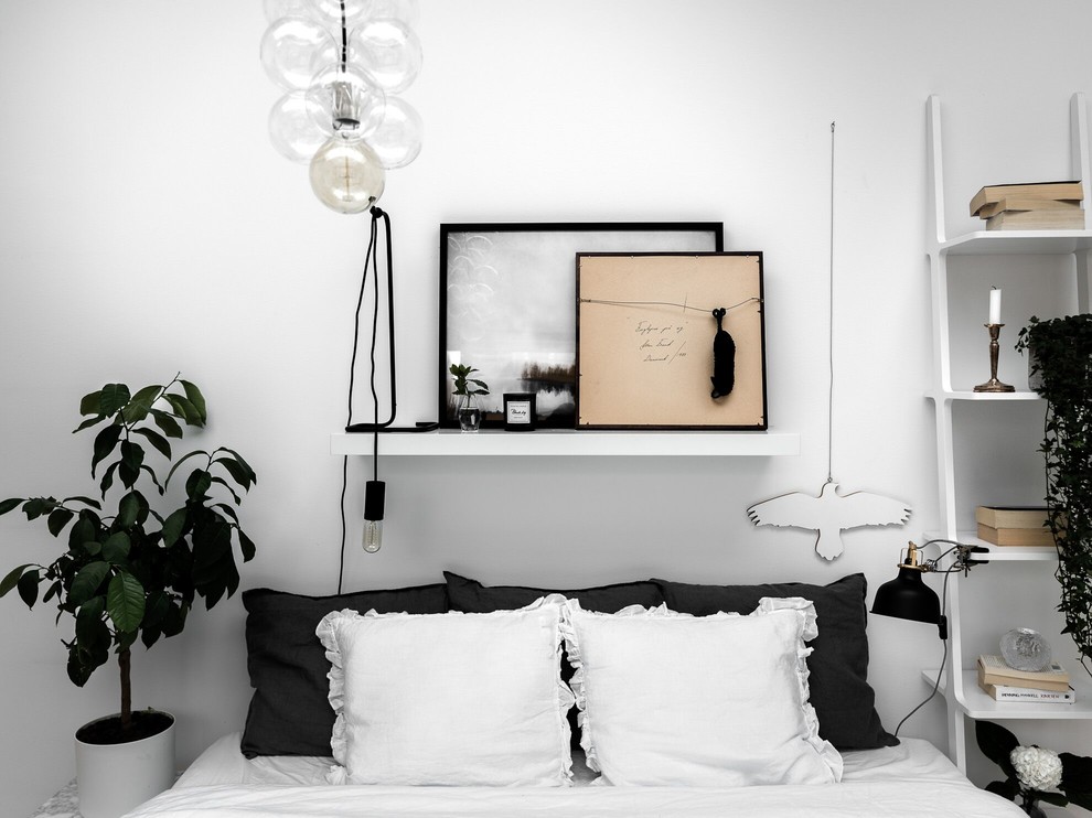 This is an example of a scandinavian master bedroom in Stockholm with white walls.