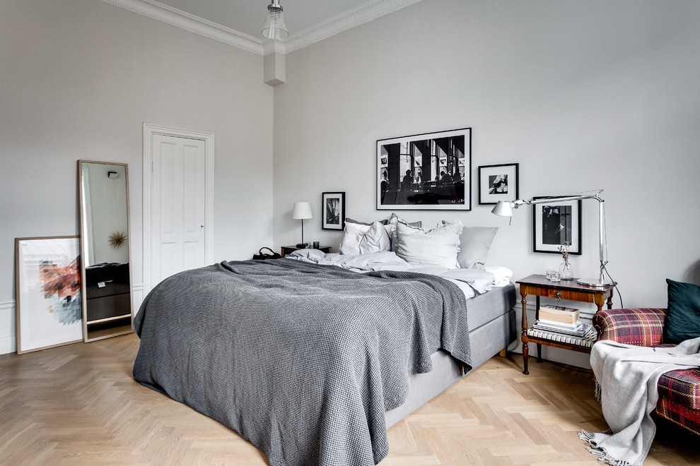 На фото: хозяйская спальня среднего размера в скандинавском стиле с серыми стенами и светлым паркетным полом с