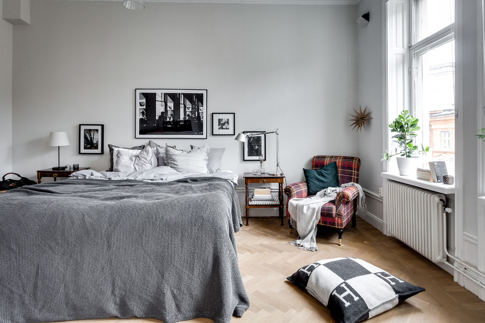 Mittelgroßes Klassisches Schlafzimmer mit grauer Wandfarbe und braunem Holzboden in Stockholm