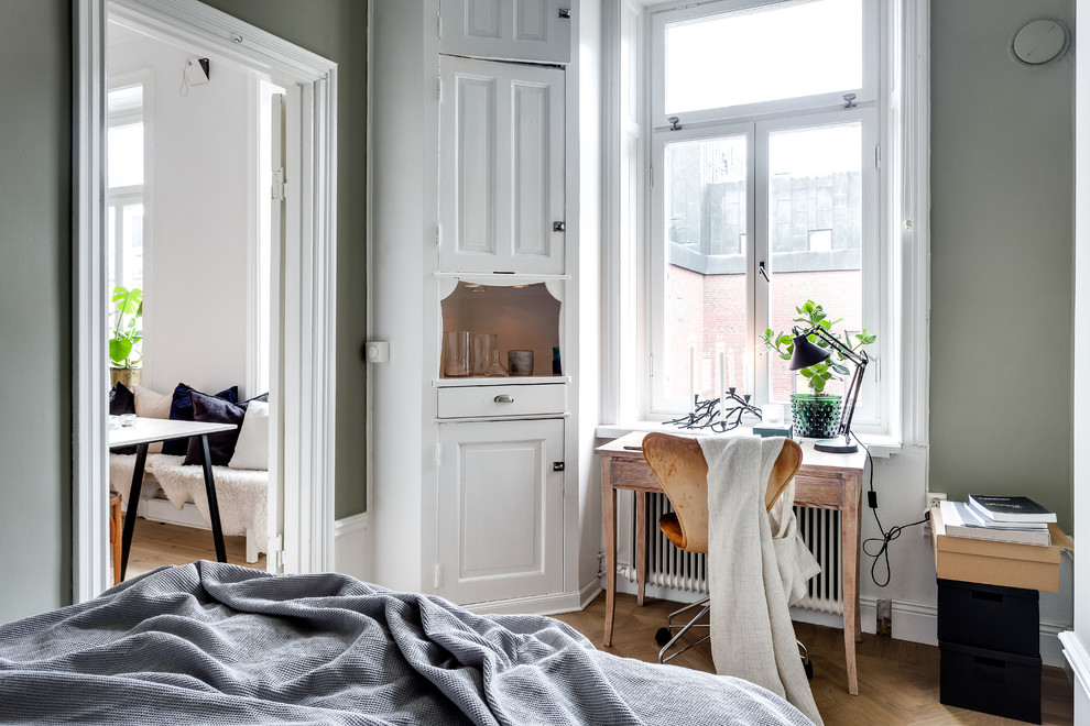 Medium sized victorian bedroom in Stockholm with green walls and medium hardwood flooring.
