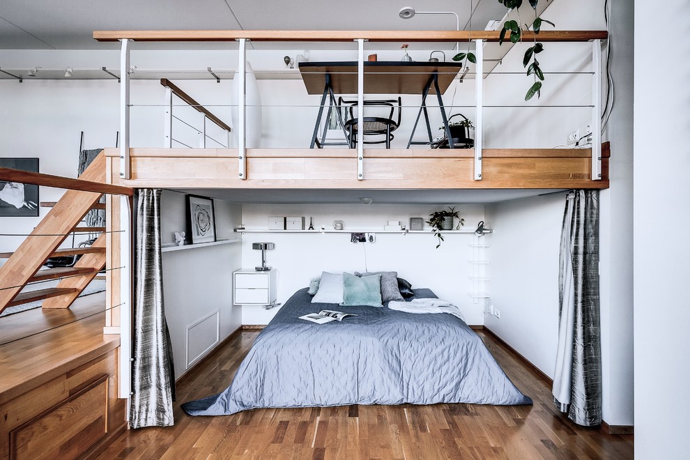 Inspiration för ett nordiskt sovrum, med vita väggar, mellanmörkt trägolv och brunt golv