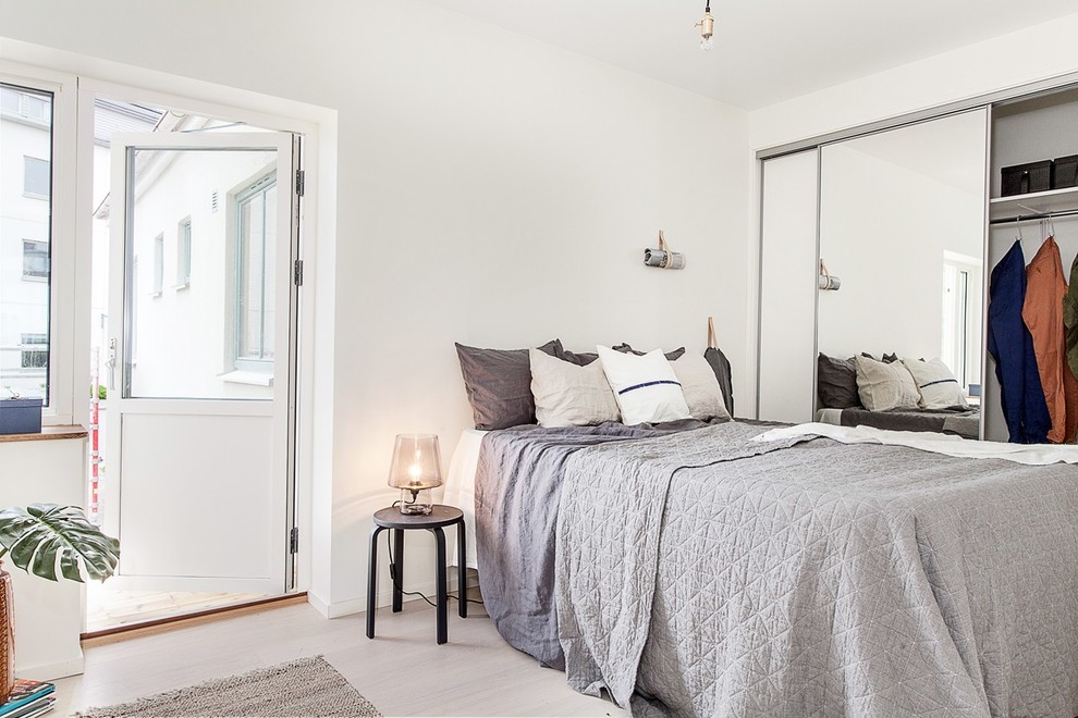 На фото: хозяйская спальня среднего размера в скандинавском стиле с белыми стенами и светлым паркетным полом без камина