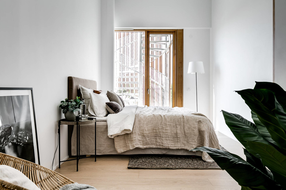 Inspiration pour une chambre parentale nordique de taille moyenne avec un mur blanc, parquet clair et un sol beige.