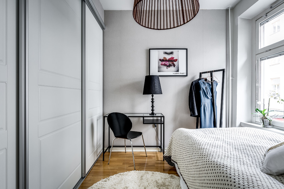 Imagen de dormitorio escandinavo con paredes blancas, suelo de madera oscura, suelo marrón y con escritorio