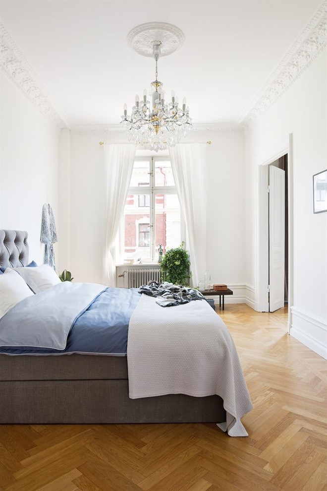 Großes Klassisches Hauptschlafzimmer ohne Kamin mit weißer Wandfarbe und hellem Holzboden in Stockholm