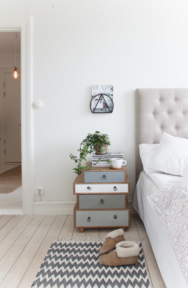 マルメにある広い北欧スタイルのおしゃれな客用寝室 (白い壁、淡色無垢フローリング、暖炉なし) のインテリア