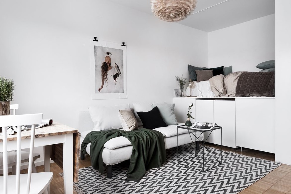 Foto på ett minimalistiskt sovrum, med vita väggar, ljust trägolv och beiget golv