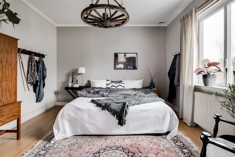 Идея дизайна: хозяйская спальня в скандинавском стиле с серыми стенами и паркетным полом среднего тона