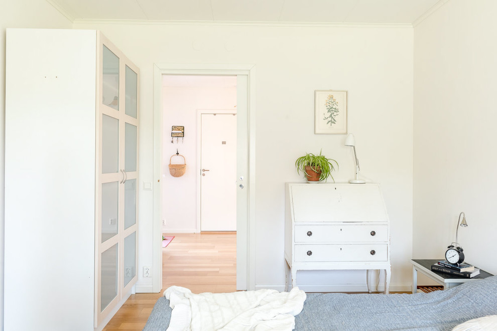На фото: гостевая спальня среднего размера, (комната для гостей) в скандинавском стиле с белыми стенами и паркетным полом среднего тона без камина с