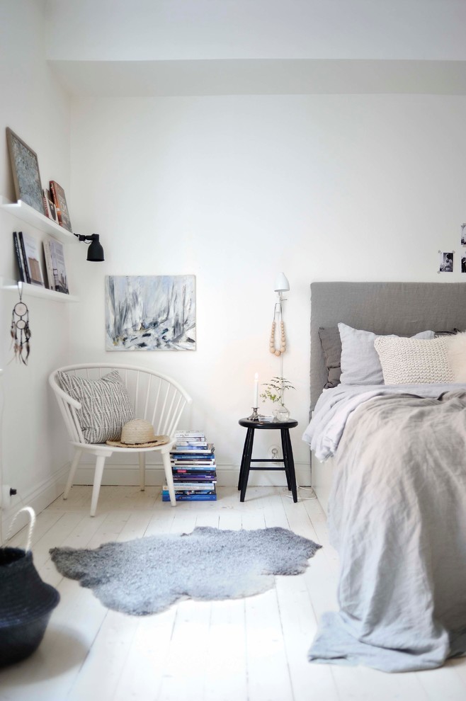 На фото: маленькая гостевая спальня (комната для гостей) в скандинавском стиле с белыми стенами и деревянным полом без камина для на участке и в саду с