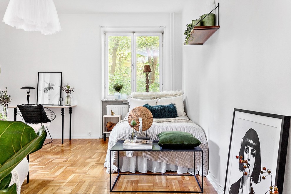 Medium sized scandinavian guest bedroom in Stockholm with white walls and light hardwood flooring.