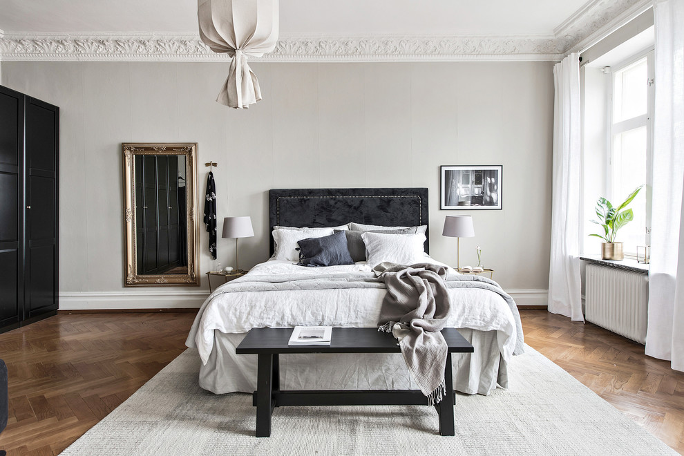 ヨーテボリにある広い北欧スタイルのおしゃれな主寝室 (無垢フローリング、暖炉なし、茶色い床、グレーの壁、グレーとブラウン) のレイアウト