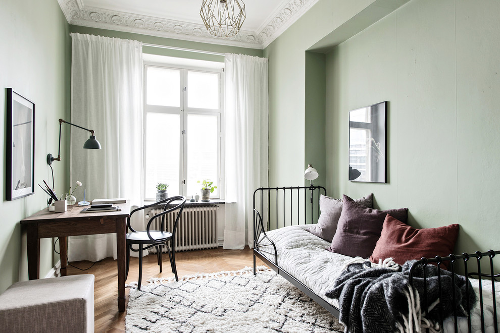 Idéer för att renovera ett mellanstort minimalistiskt gästrum, med gröna väggar, mellanmörkt trägolv och beiget golv