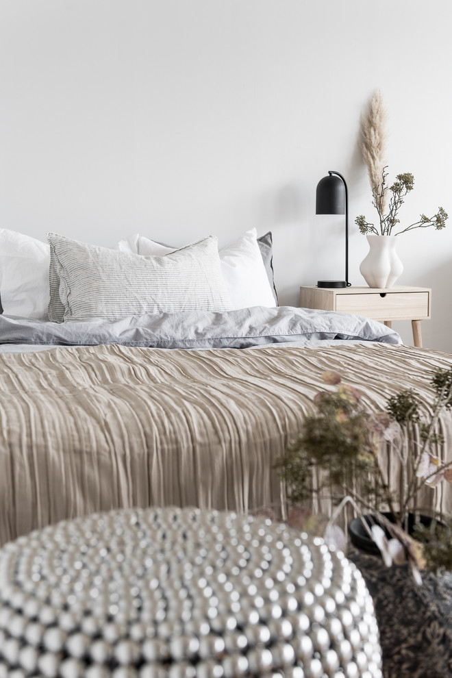 Diseño de dormitorio principal nórdico pequeño con paredes blancas y suelo de madera en tonos medios
