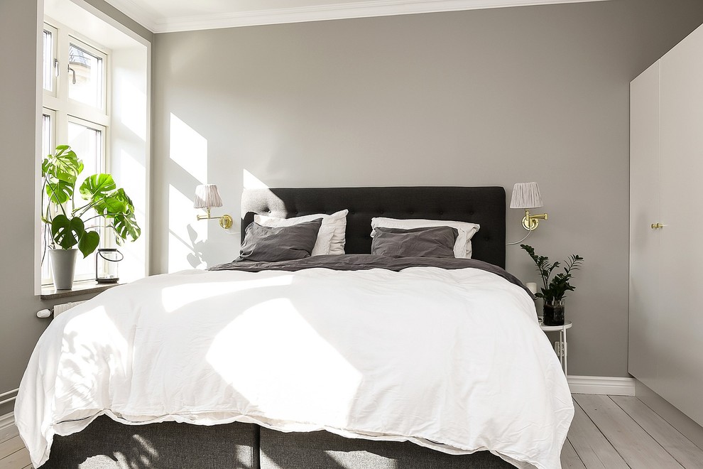 Klassisk inredning av ett sovrum, med grå väggar, ljust trägolv och vitt golv
