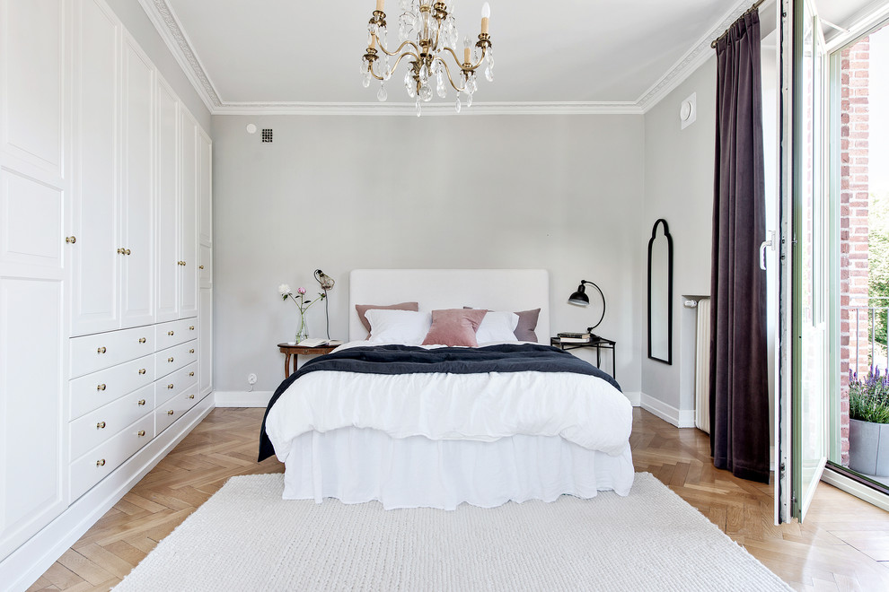 Imagen de dormitorio escandinavo con paredes grises, suelo de madera clara y suelo beige