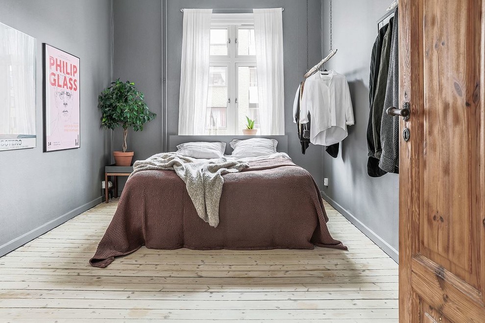 Immagine di una camera da letto nordica di medie dimensioni con pareti grigie, parquet chiaro e pavimento beige
