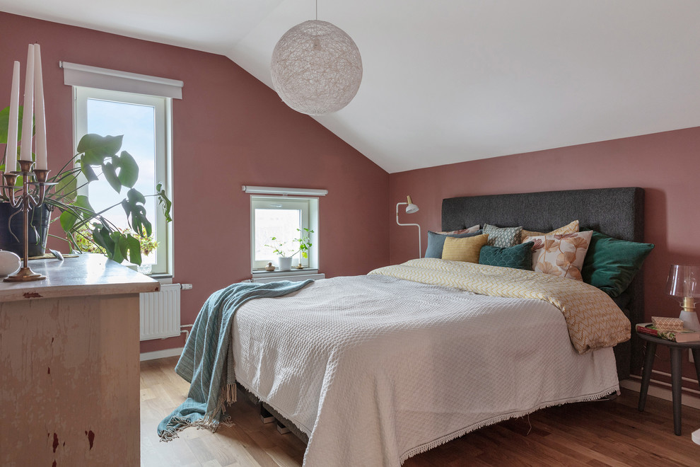 Inspiration för ett funkis gästrum, med rosa väggar, mellanmörkt trägolv och brunt golv