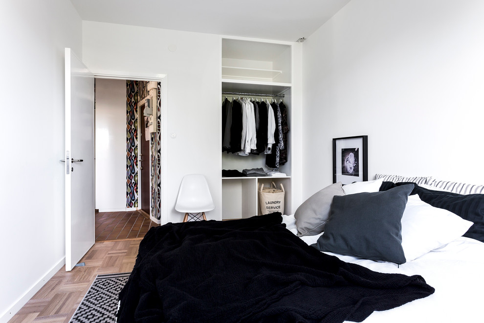 This is an example of a medium sized scandinavian master bedroom in Stockholm with white walls, medium hardwood flooring and no fireplace.