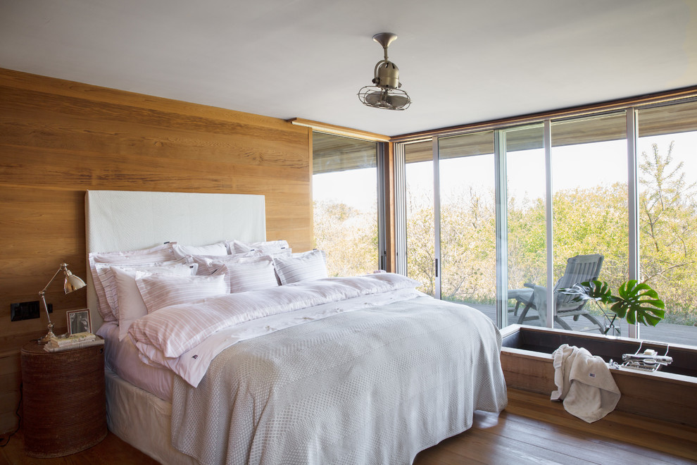 Esempio di una camera da letto design di medie dimensioni con pareti marroni, pavimento in legno massello medio, nessun camino e pavimento marrone