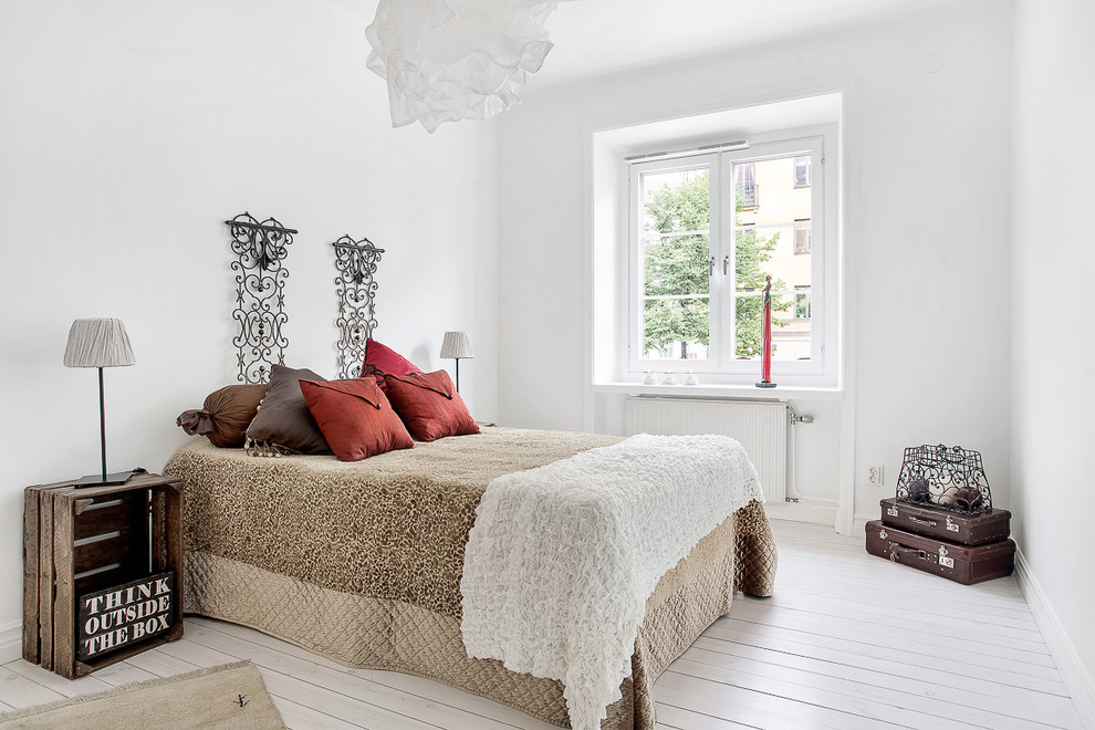 Modelo de dormitorio principal nórdico grande sin chimenea con paredes blancas y suelo de madera pintada