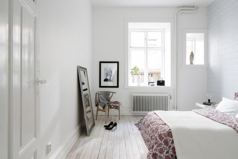 Mittelgroßes Nordisches Hauptschlafzimmer ohne Kamin mit weißer Wandfarbe und gebeiztem Holzboden in Malmö