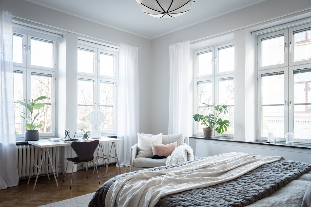Design ideas for a scandi grey and brown bedroom in Gothenburg with grey walls, medium hardwood flooring and brown floors.