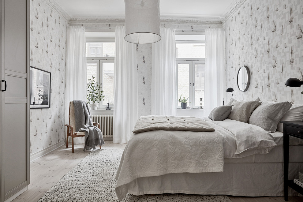 На фото: большая хозяйская спальня в скандинавском стиле с серыми стенами, светлым паркетным полом и серым полом без камина с