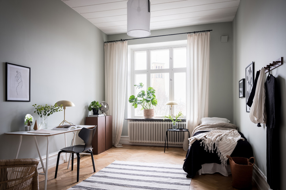 Cette photo montre une chambre scandinave avec un mur bleu, parquet clair et un sol beige.