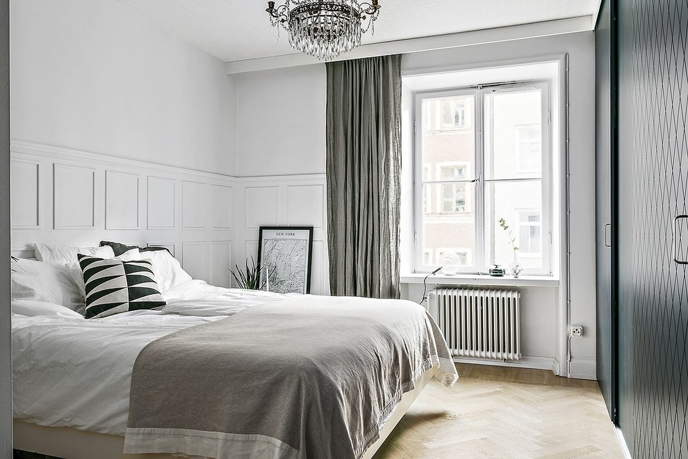 Medium sized scandi master bedroom in Stockholm with white walls, light hardwood flooring and beige floors.
