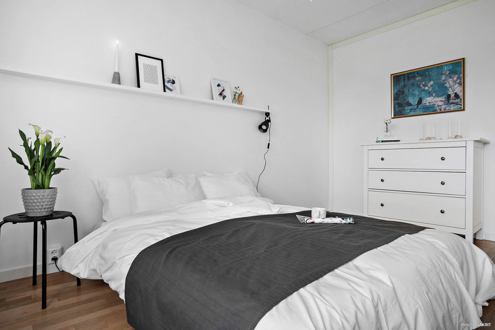 На фото: большая хозяйская спальня в скандинавском стиле с белыми стенами, паркетным полом среднего тона и бежевым полом