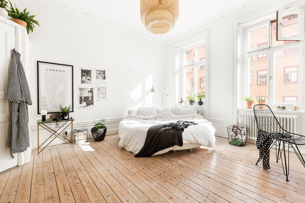 Mittelgroßes Skandinavisches Hauptschlafzimmer ohne Kamin mit weißer Wandfarbe und hellem Holzboden in Stockholm