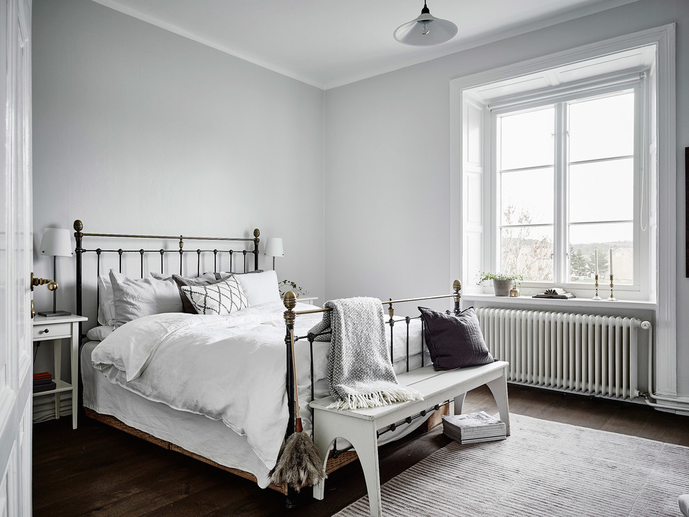 Стильный дизайн: хозяйская спальня среднего размера в скандинавском стиле с серыми стенами, темным паркетным полом и кроватью в нише без камина - последний тренд