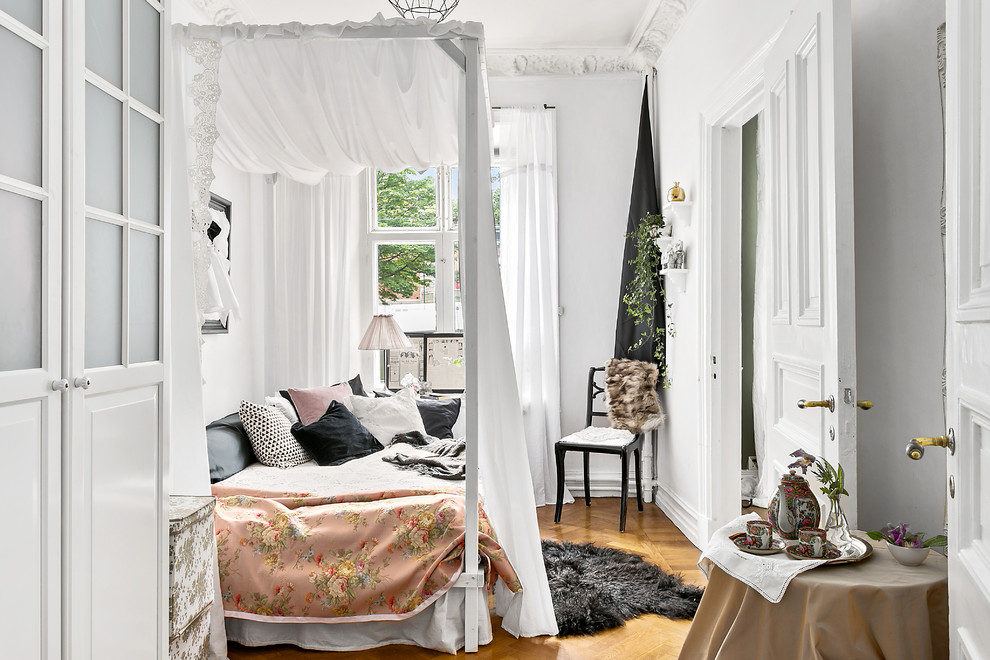 Skandinavisches Schlafzimmer ohne Kamin mit weißer Wandfarbe und braunem Holzboden in Göteborg