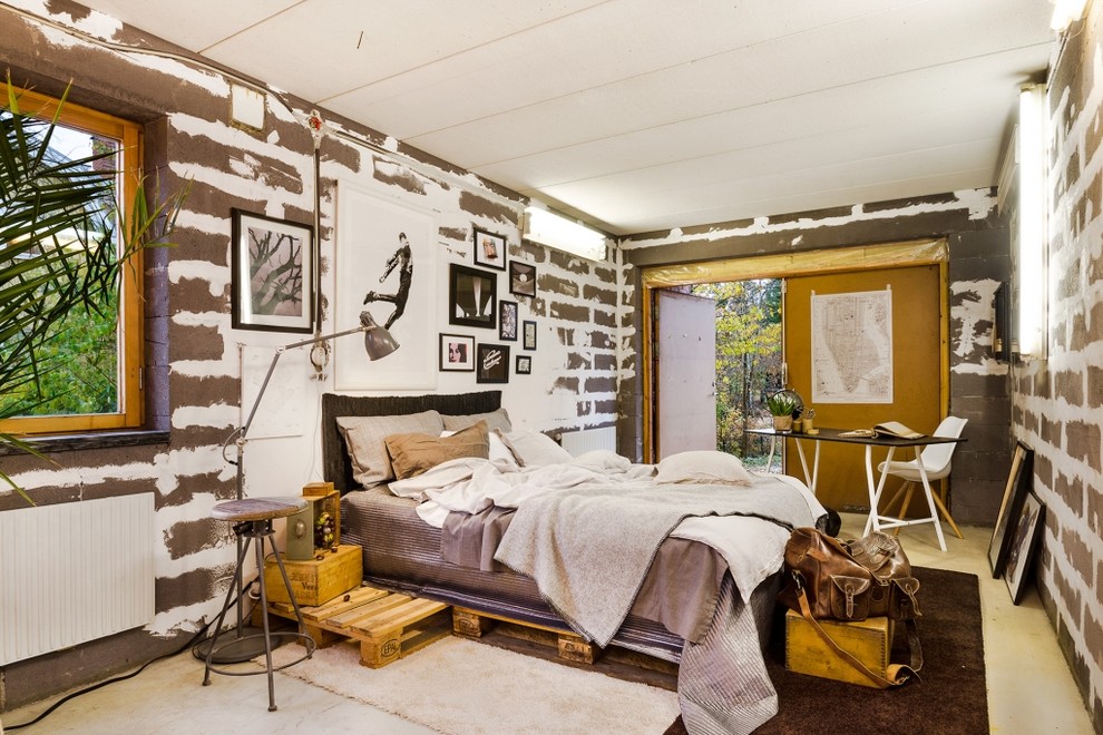 Großes Industrial Hauptschlafzimmer ohne Kamin mit grauer Wandfarbe und Betonboden in Stockholm