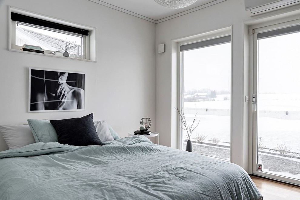 Example of a danish master light wood floor and beige floor bedroom design in Malmo with gray walls