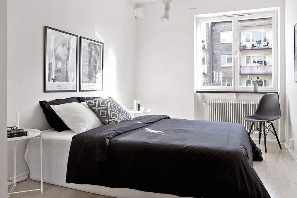 Design ideas for a scandinavian bedroom in Malmo with white walls and light hardwood flooring.