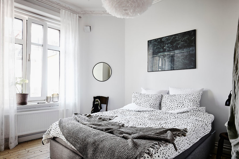 Example of a mid-sized danish master medium tone wood floor bedroom design in Gothenburg with gray walls