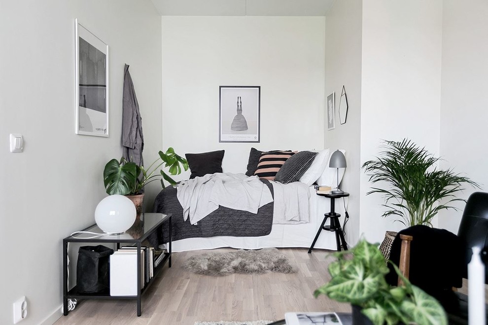 Foto de dormitorio principal nórdico pequeño sin chimenea con paredes blancas, suelo de madera clara y suelo beige