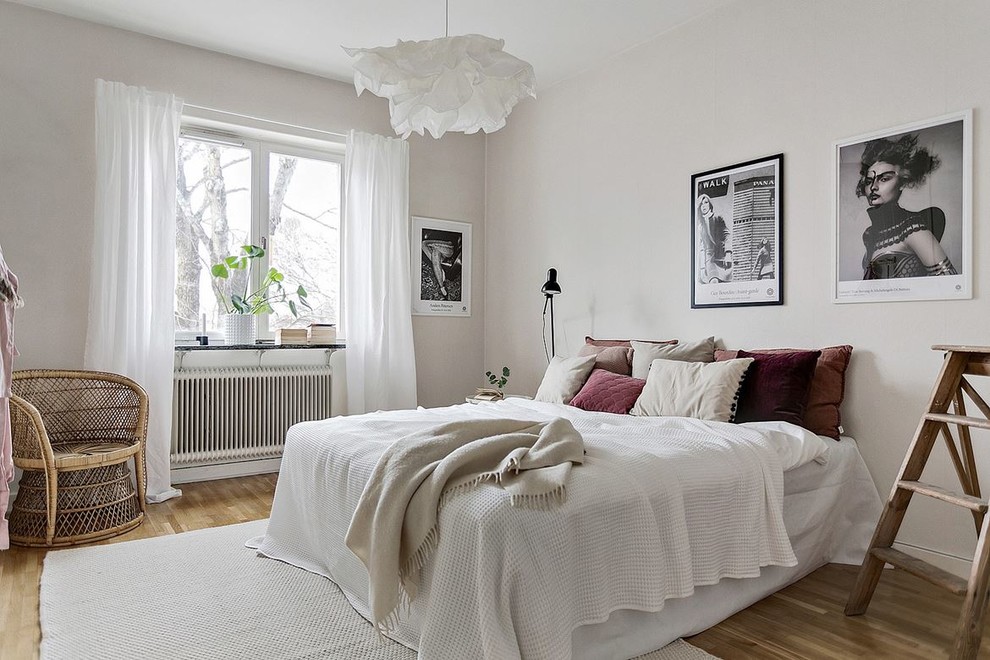 На фото: спальня среднего размера в скандинавском стиле с белыми стенами, паркетным полом среднего тона и бежевым полом с