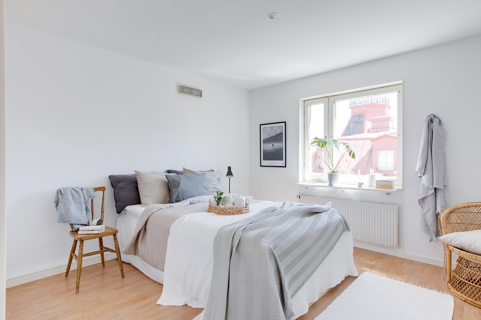 Aménagement d'une chambre d'amis scandinave avec un mur blanc, parquet clair et un sol beige.