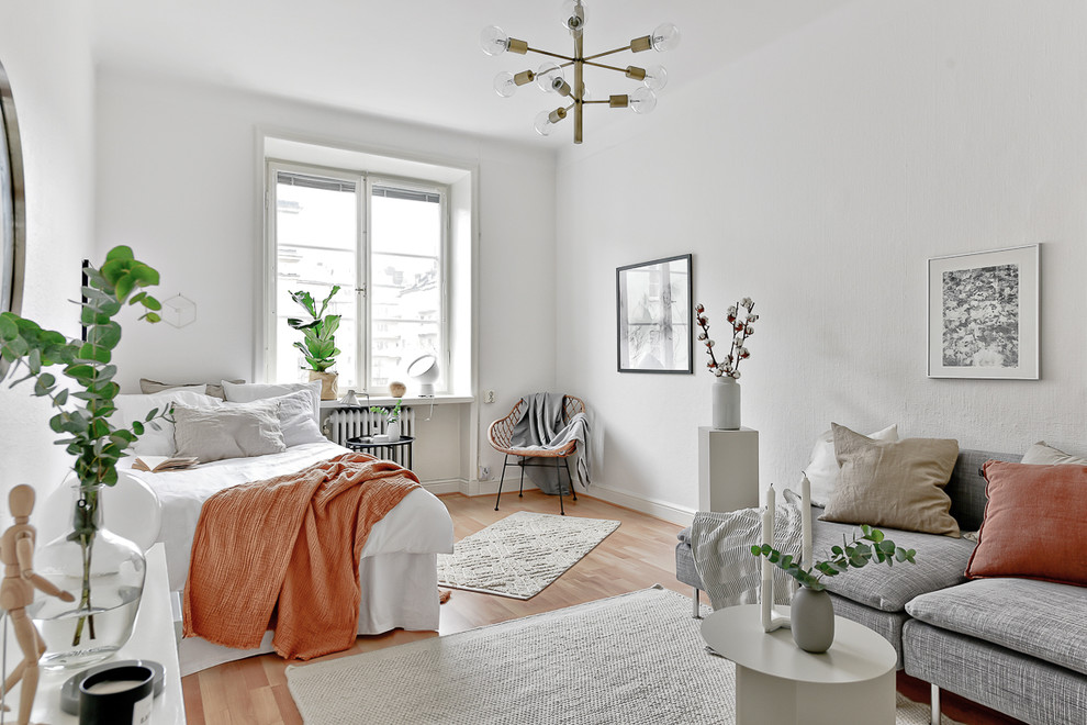 Exemple d'une chambre scandinave de taille moyenne avec un mur blanc, un sol en bois brun et un sol beige.