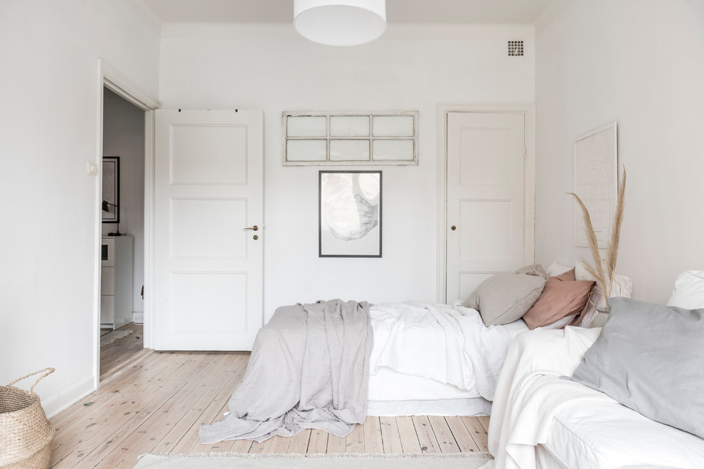 Idéer för ett mellanstort nordiskt sovrum, med vita väggar, ljust trägolv och beiget golv