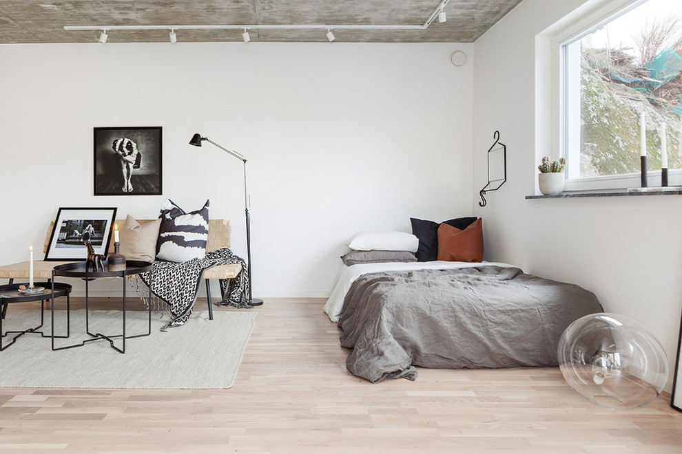 Industrial Schlafzimmer mit weißer Wandfarbe und hellem Holzboden in Stockholm