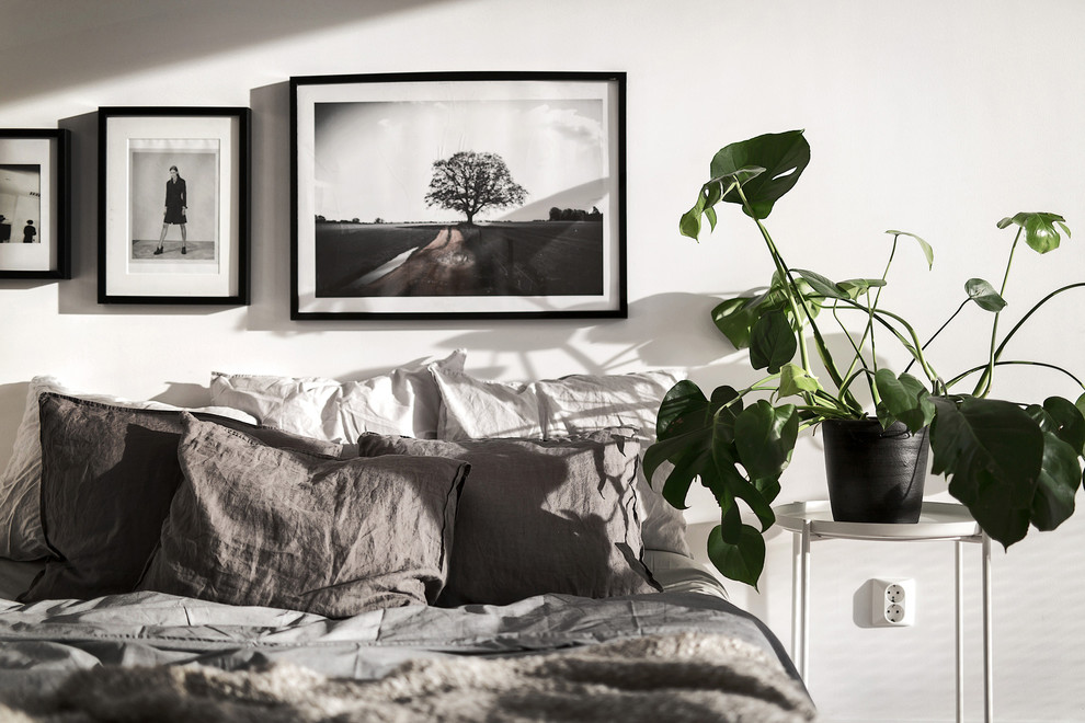Стильный дизайн: хозяйская спальня в скандинавском стиле с белыми стенами и светлым паркетным полом - последний тренд