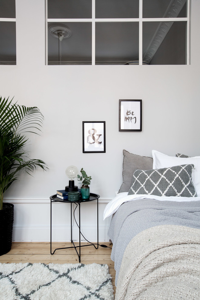 Idéer för att renovera ett mellanstort minimalistiskt gästrum, med grå väggar och ljust trägolv