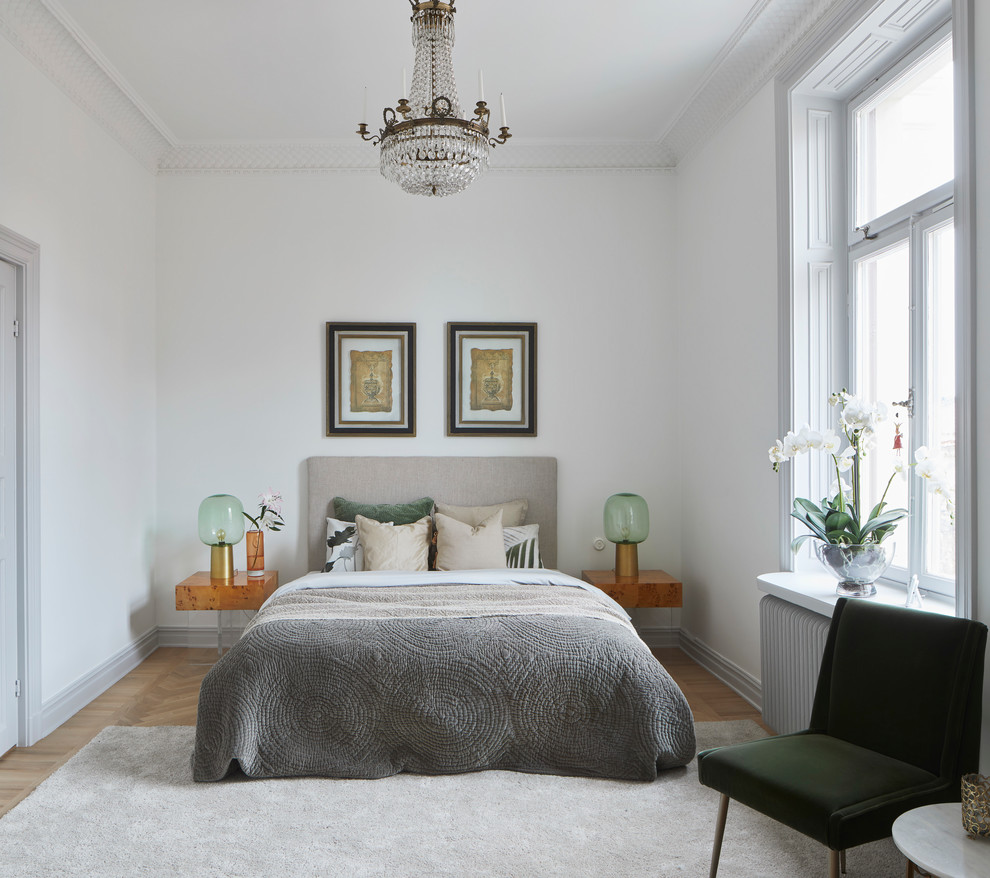 Foto på ett nordiskt sovrum, med vita väggar, ljust trägolv och beiget golv